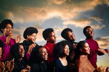 1980s Young African American men and women in a gospel choir singing in front of a sunrise stage (P...