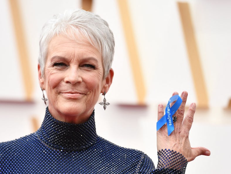 US actress Jamie Lee Curtis wears a ribbon on her hand reading "#WithRefugees" attends the 94th Osca...