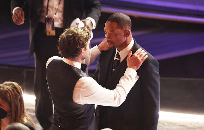 HOLLYWOOD, CA - March 27, 2022.   Bradley Cooper comforts Will Smith  during the show  at the 94th A...
