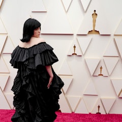 Billie Eilish wears a full-length tiered Gucci gown on the 2022 Oscars red carpet. 