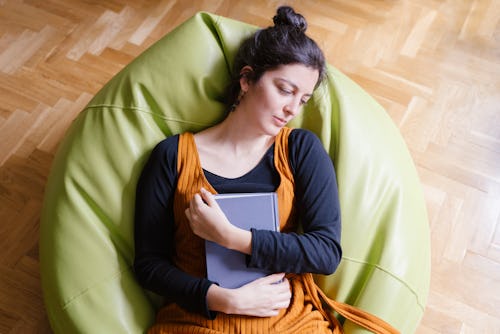 A woman lies in a bean bag chair. Here's your daily horoscope for March 29, 2022.