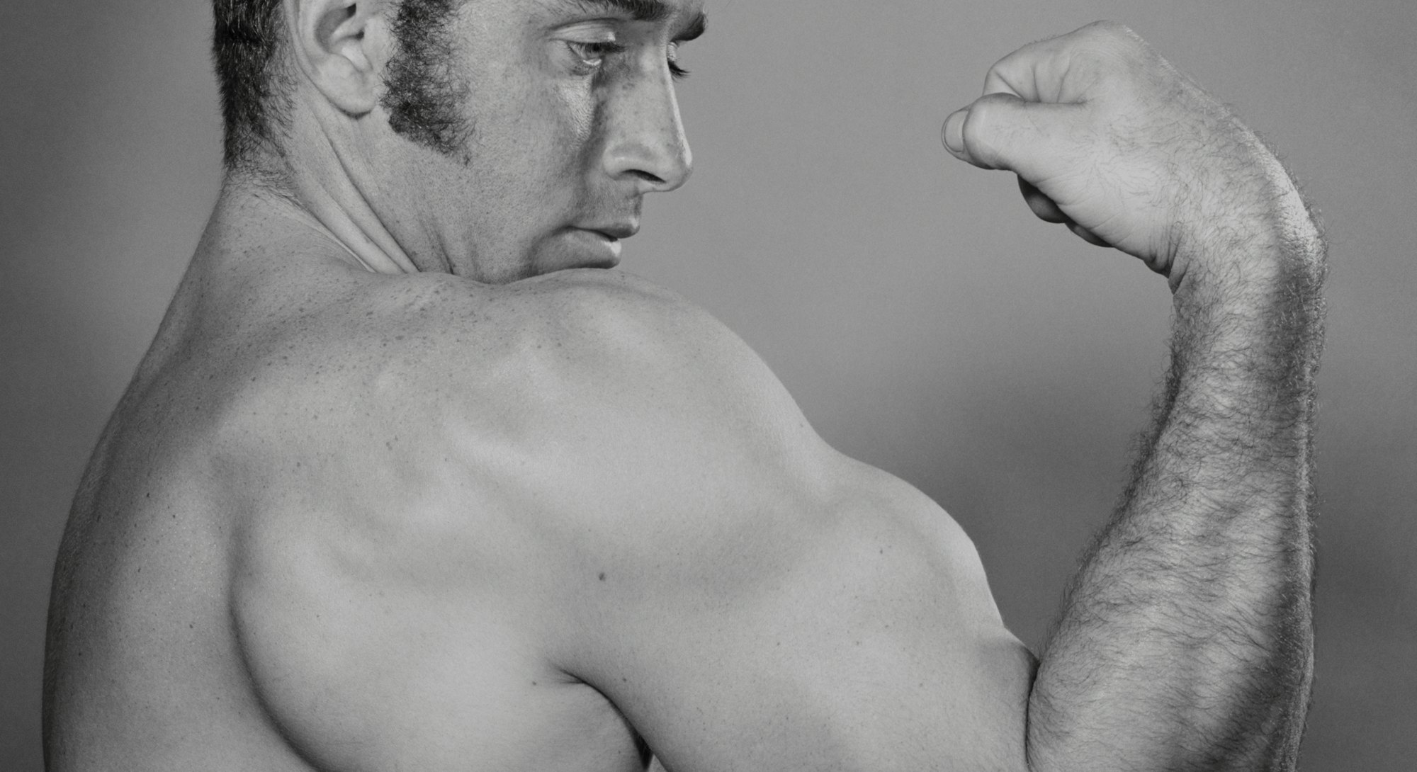 1970s MALE BODY-BUILDER PROUDLY SHOWING OFF LARGE MUSCULAR BICEPS  (Photo by H. Armstrong Roberts/Cl...