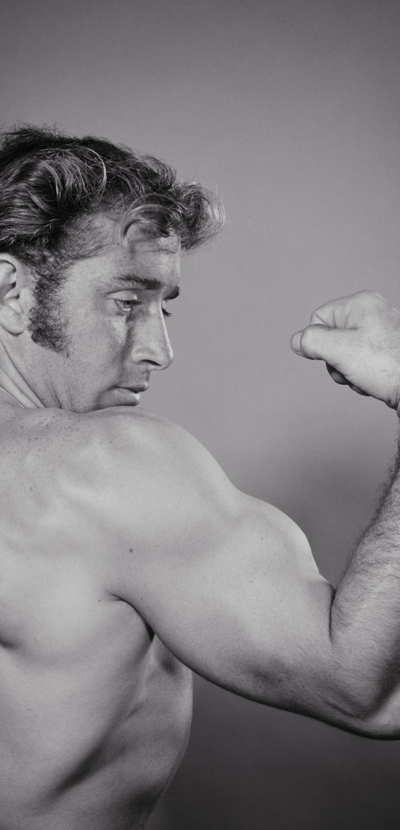 1970s MALE BODY-BUILDER PROUDLY SHOWING OFF LARGE MUSCULAR BICEPS  (Photo by H. Armstrong Roberts/Cl...