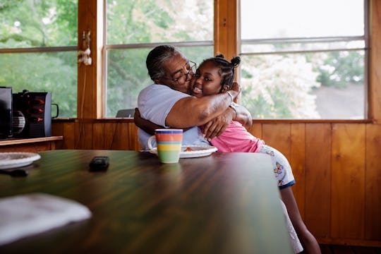 Black grandmother hugging her small granddaughter.