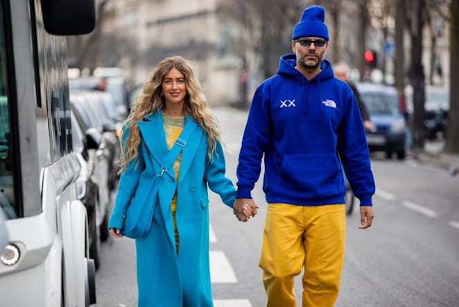 PARIS, FRANCE - MARCH 02: Couple Emili Sindlev wearing blue coat, Hermes bag, yellow pants, blue hee...