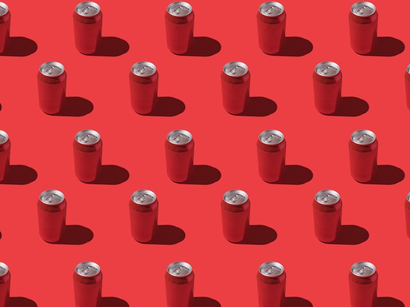 Red soda cans pattern with hard shadow on red background.