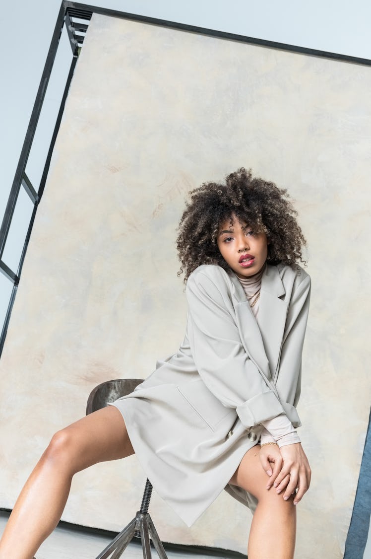 Young woman in an oversized sweater before reading her March 2022 full moon horoscope.