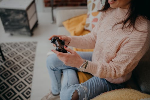 Young woman playing the best '90s video games at home.