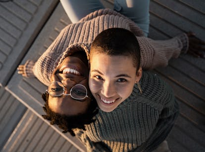 two women looking up and smiling at camera as they discuss zodiac sign compatibility