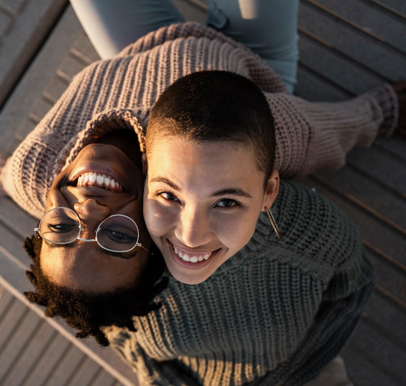 two women looking up and smiling at camera as they discuss zodiac sign compatibility