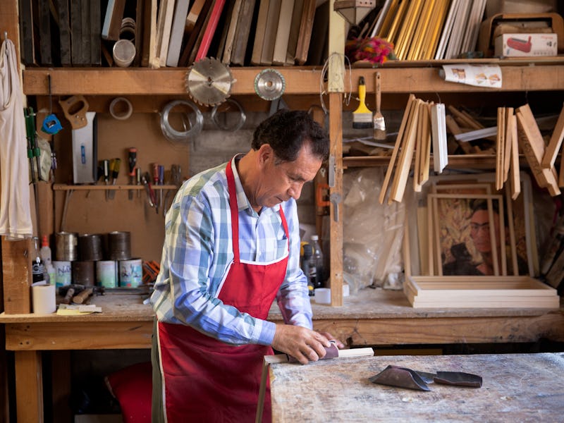 A friendly looking middle-aged picture framer in his workshop