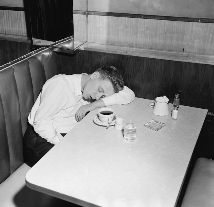 Premium Rates Apply. A young man falls asleep over a cup of coffee in a New York cafe.  (Photo by We...