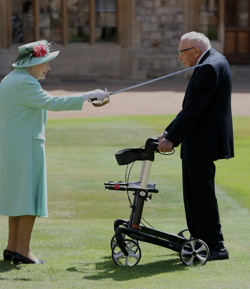 WINDSOR, ENGLAND - JULY 17: Queen Elizabeth II awards Captain Sir Thomas Moore with the insignia of ...
