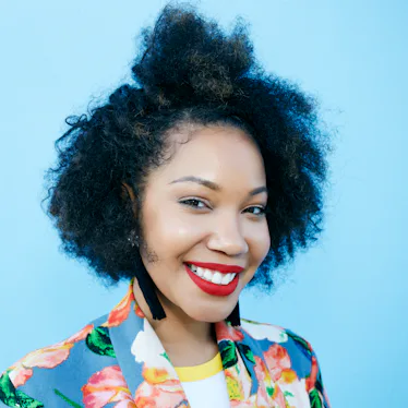 Young woman with curly hair smiling, knowing her zodiac sign will have the best week of April 4, 202...