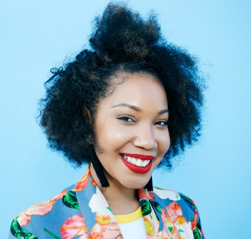 Young woman with curly hair smiling, knowing her zodiac sign will have the best week of April 4, 202...