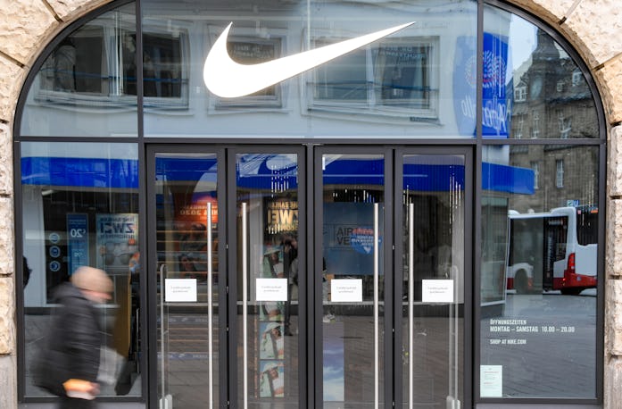 01 April 2020, Hamburg: A man walks in front of the closed entrance of a department store of the spo...