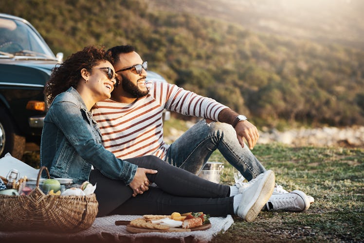 Shot of a young couple enjoying a romantic picnic outdoors, which is one of the spring break ideas f...