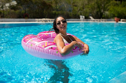 A beautiful girl in an inflatable donut is having fun in the pool