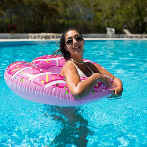 A beautiful girl in an inflatable donut is having fun in the pool