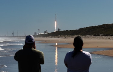People watch from Canaveral National Seashore as a SpaceX Falcon 9 rocket launches from pad 39A at t...