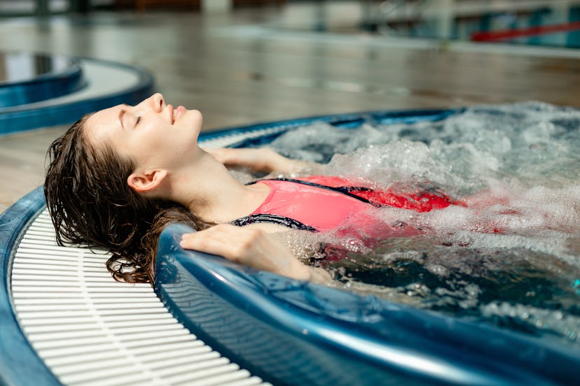 Portrait of nice woman who swim in the spa and hot tub of swimming pool. Concept with modern girl an...