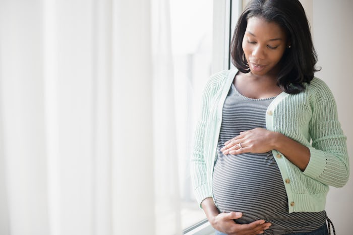 pregnant woman standing by window
