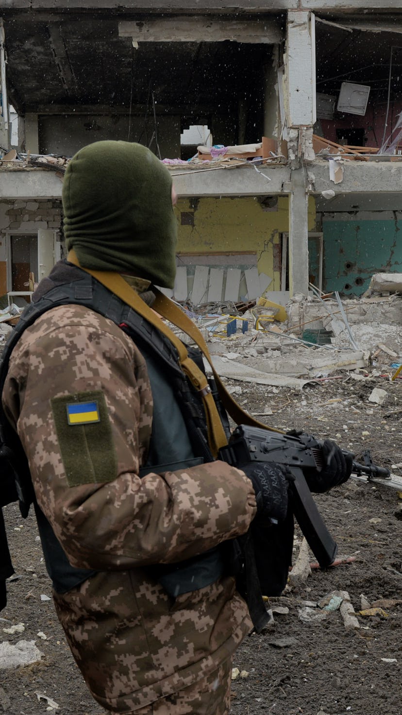 A member of the Ukrainian Territorial Defence Forces looks at destructions following a shelling in U...
