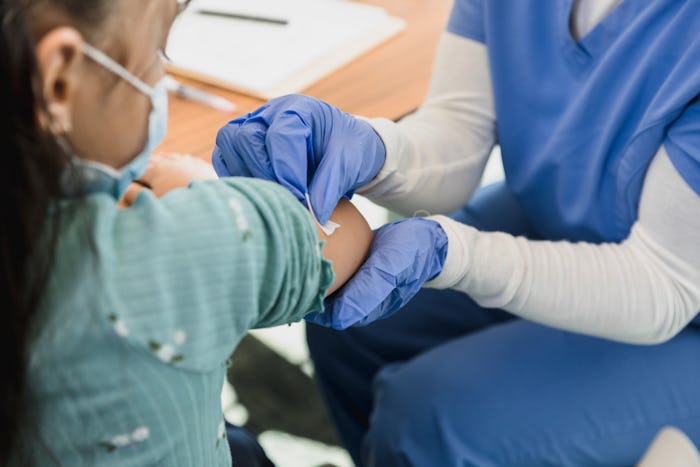 The medical professional prepares the injection site where they will administer the vaccine.