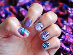 water marble nail art in purple, magenta, bluegreen and white. close-up