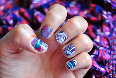 water marble nail art in purple, magenta, bluegreen and white. close-up