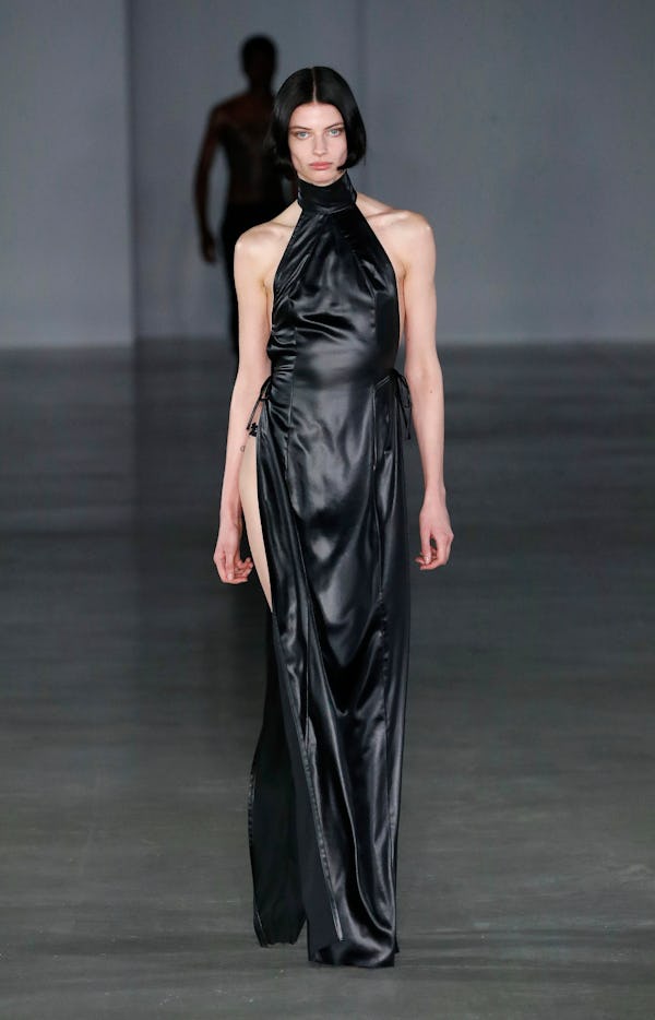 a model wearing a leather halter maxi dress with a slit on the Ludovic De Saint-Sernin runway