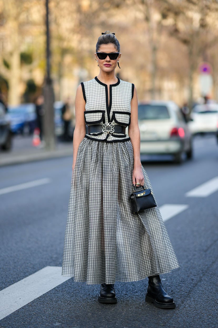 PARIS, FRANCE - MARCH 05: Lala Rudge wears black sunglasses, gold and diamond earrings, a white with...