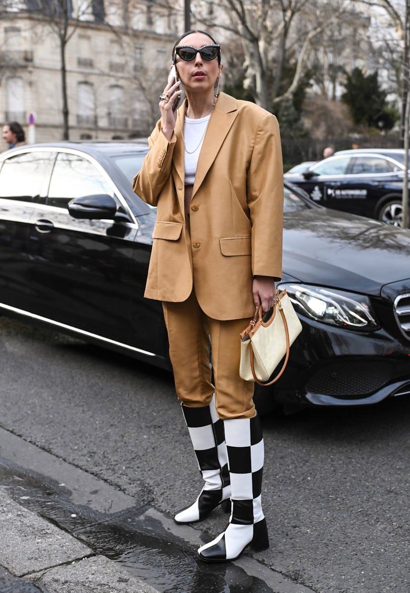 PARIS, FRANCE - MARCH 03: A guest is seen wearing a tan faux leather coat and faux leather pants wit...