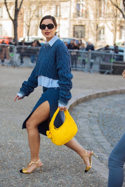 PARIS, FRANCE - MARCH 08: Bettina Looney wears black sunglasses, a blue Miu Miu cropped knit sweater...