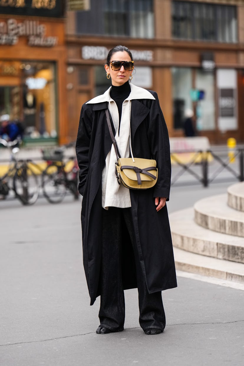 PARIS, FRANCE - MARCH 01: Ilenia Toma wears sunglasses, gold earrings, a black turtleneck pullover, ...