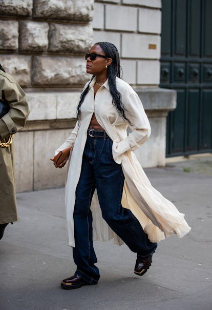PARIS, FRANCE - MARCH 05: A guest is seen wearing white long button up shirt, dark denim jeans outsi...