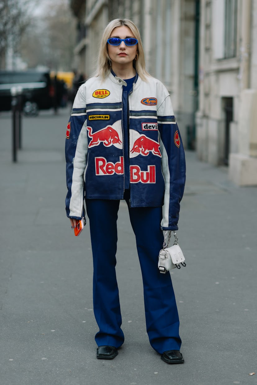 PARIS, FRANCE - MARCH 02: A guest poses wearing a Red Bull motorcycle leather jacket before the Acne...