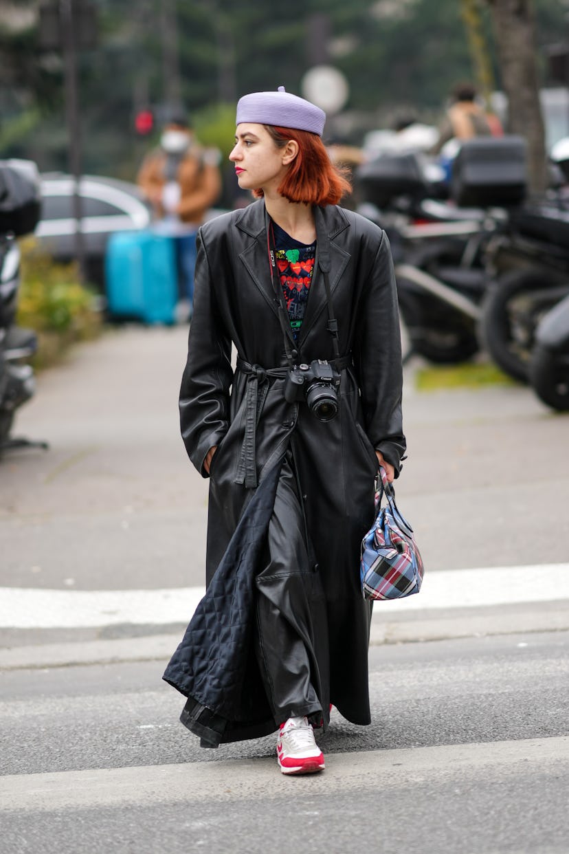 PARIS, FRANCE - MARCH 04: A guest wears a pale purple felt beret, a black with red and green print p...