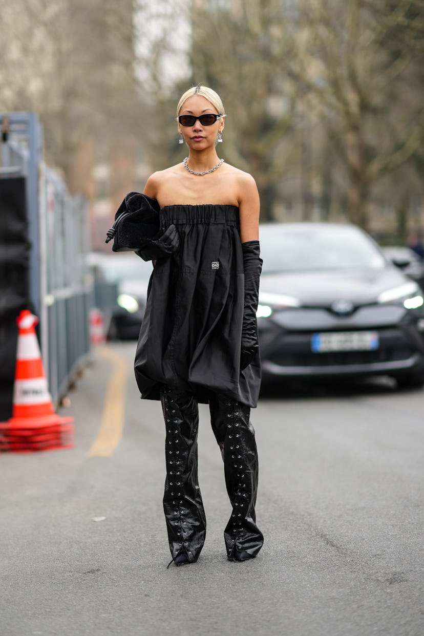 PARIS, FRANCE - MARCH 04: Vanessa Hong wears black sunglasses, silver earrings, a silver large chain...