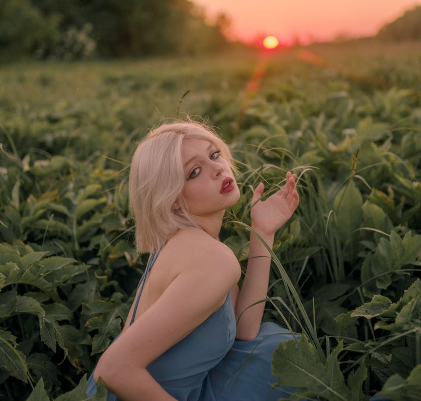 Young woman watching the sunset, embracing the spiritual meaning of the March 2022 full Worm Moon in...