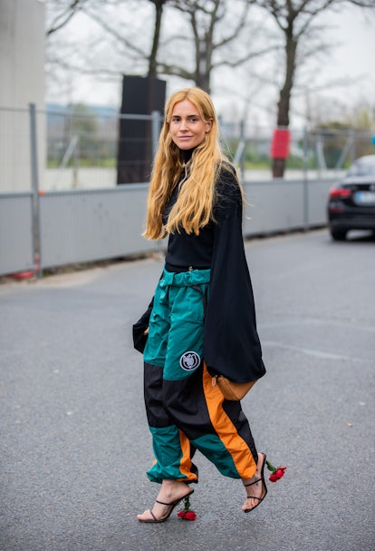 PARIS, FRANCE - MARCH 04: Blanca Miro Scrimieri seen wearing mint green black pants with orange stri...