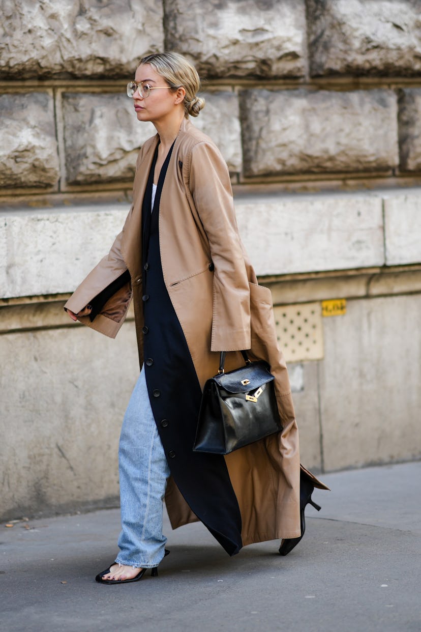 PARIS, FRANCE - MARCH 05: A guest wears glasses, a white tank-top, a black long velvet jacket, a bro...