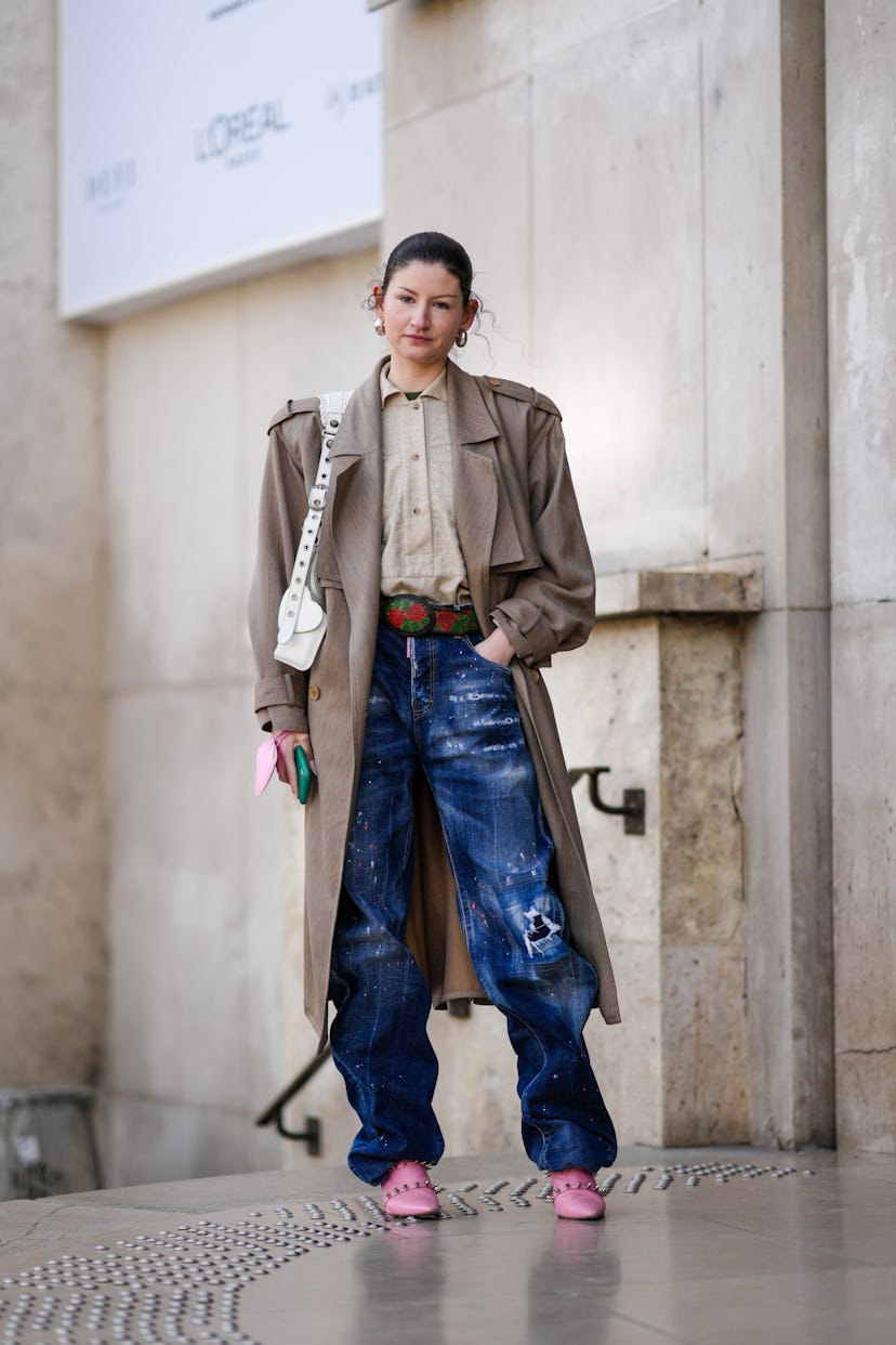 PARIS, FRANCE - MARCH 05: A guest wears silver large earrings, a black t-shirt, a beige shirt, a bro...