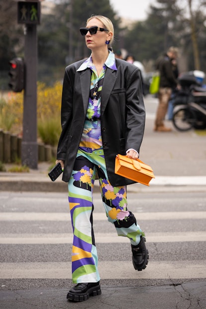 PARIS, FRANCE - MARCH 04: A guest wearing a colorful printed shirt with matching pants, black leathe...