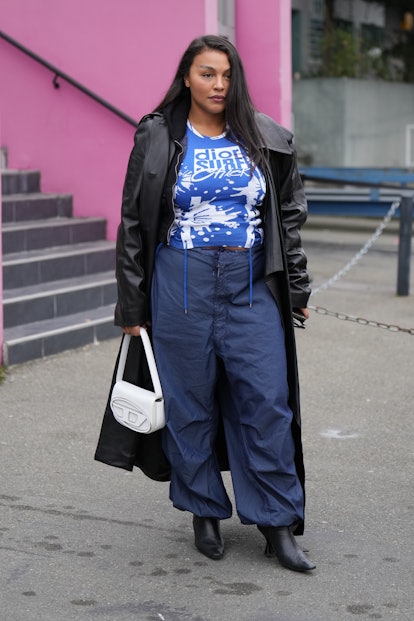 PARIS, FRANCE - MARCH 03: A guest wears a blue and white print pattern t-shirt from Dior, a black sh...