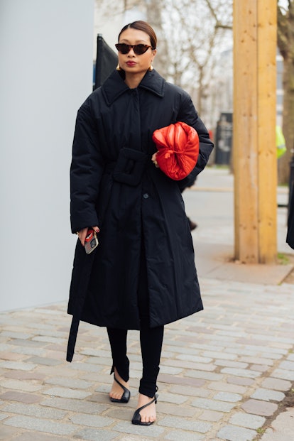 PARIS, FRANCE - MARCH 04: Rosie Lai wears a black jacket with an oversized buckle, red handbag by he...