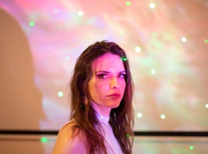 Young woman illuminated by starry lights, thinking about the March 2022 full Worm Moon on March 18, ...