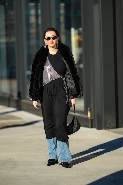 NEW YORK, NEW YORK - FEBRUARY 14: A guest wears black sunglasses, silver and rhinestones pendant ear...
