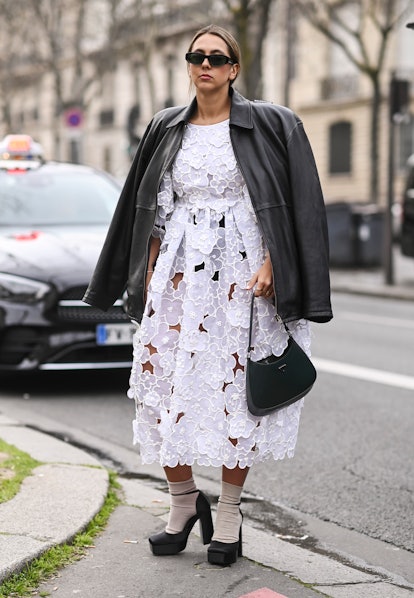 PARIS, FRANCE - MARCH 02: A guest is seen wearing a Cecilie Bahnsen white dress, black jacket, Prada...