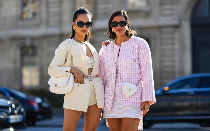 PARIS, FRANCE - MARCH 08: Anna Rosa Vitiello (L) wears black sunglasses, gold earrings, a silver cha...